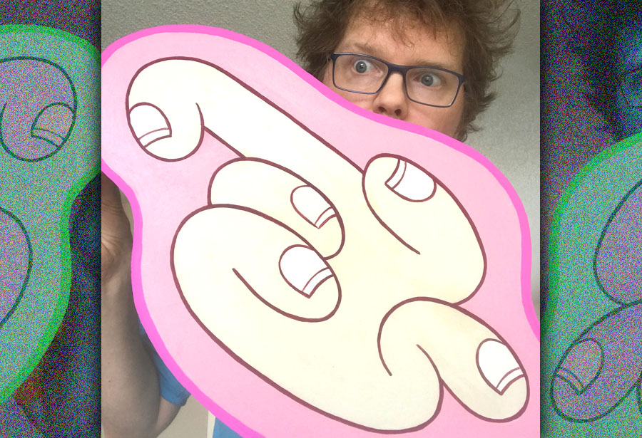 R. Thies holding up a wood panel painting of abstract cartoon-style fingers (fingies), eyes and nose visible above the artwork